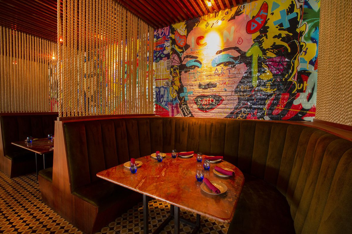 A pop-art painting of Marilyn Monroe behind a curved booth.