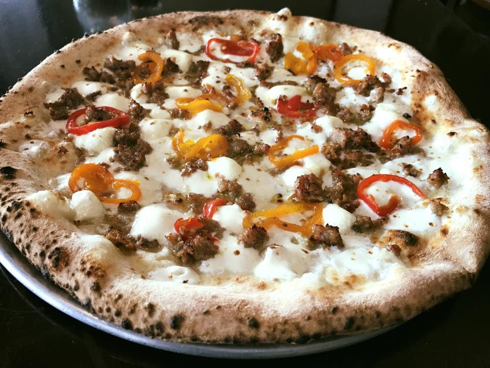 Pizaro’s wood-fired pizza, topped with peppers, sausage and gooey cheese