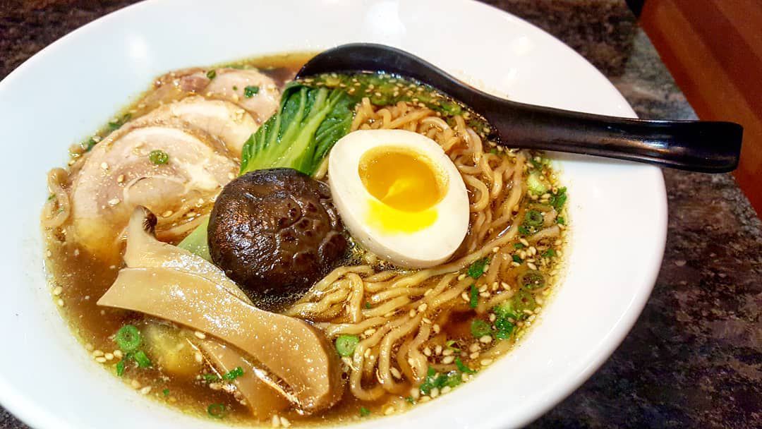 A bowl of ramen with an egg, noodles, mushrooms, and more