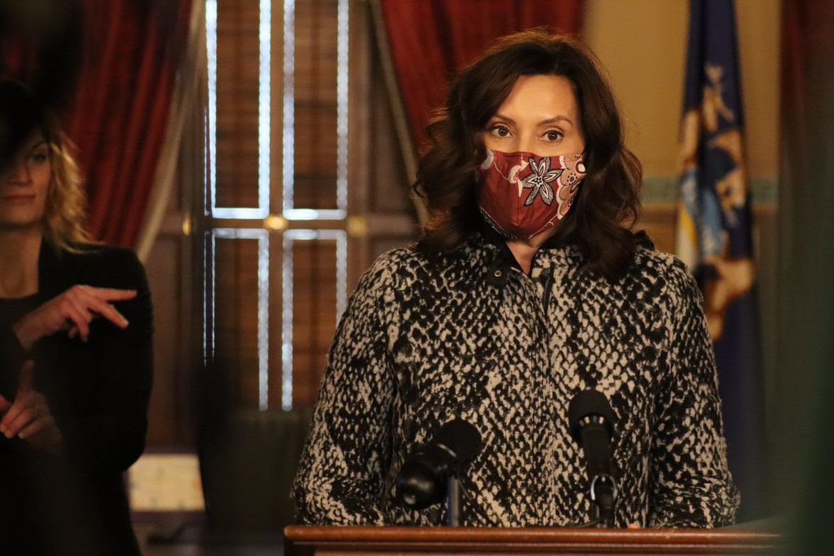 Michigan Governor Gretchen Whitmer speaks at a podium while wearing a protective mask.
