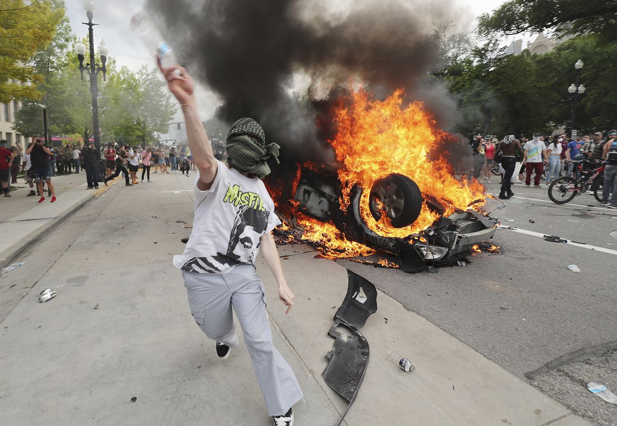A protester throws a water bottle at police in Salt Lake City on Saturday, May 30, 2020. Protesters joined others across the nation to decry the death of George Floyd, a black man, who died while being taken into custody by police in Minneapolis earlier this week.