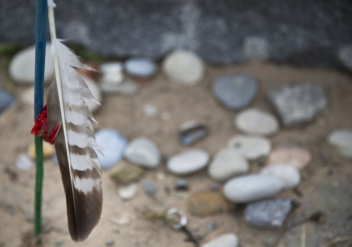 In this May 1, 2019 photo, a feather and stones are left at the Charles Shay Memorial at Omaha Beach in Saint-Laurent-sur-Mer, Normandy, France. Shay, was a medic who on June 6, 1944, landed on Omaha Beach, where he helped drag wounded soldiers out of the