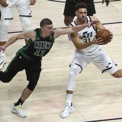 Boston Celtics guard Payton Pritchard (11) stretches for the ball as Utah Jazz forward Georges Niang (31) spins away from him during an NBA basketball game at Vivint Smart Home Arena in Salt Lake City on Tuesday, Feb. 9, 2021.