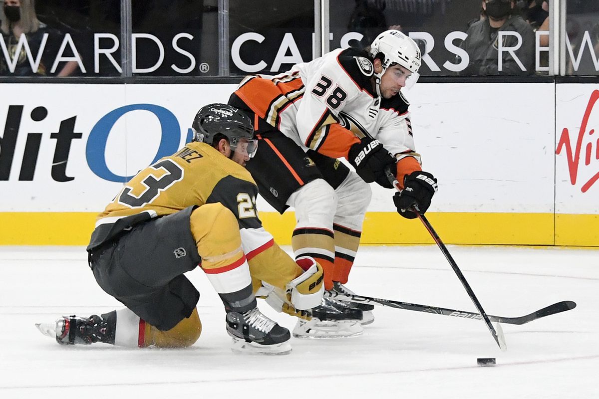 Derek Grant #38 of the Anaheim Ducks passes under pressure from Alec Martinez #23 of the Vegas Golden Knights in the third period of their game at T-Mobile Arena on January 16, 2021 in Las Vegas, Nevada. The Golden Knights defeated the Ducks 2-1 in overtime.