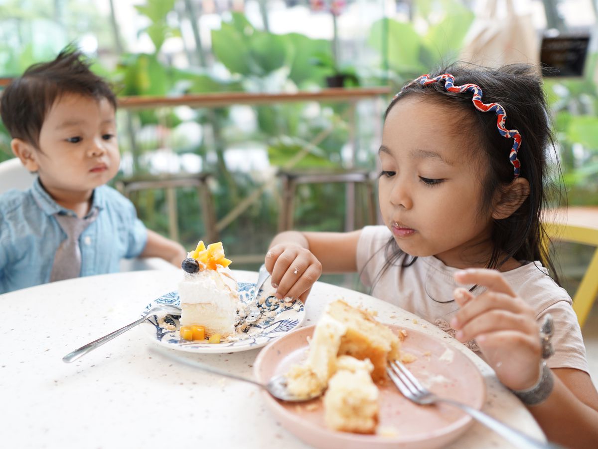 Kids eat cake at a table. 