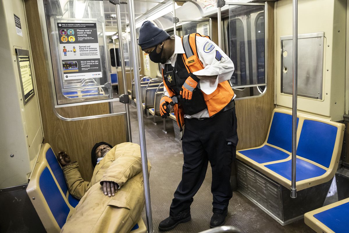 Security guard Troy Fulcher checks on an ‘L’ rider at the Blue Line Forest Park station, where the Night Ministry was providing free health care and other outreach services Wednesday night.