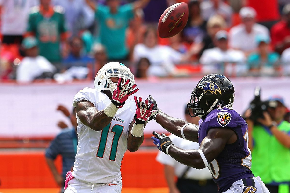 MIAMI GARDENS, FL - OCTOBER 06: Mike Wallace #11 of the Miami Dolphins makes a catch against Matt Elam #26 of the Baltimore Ravens during a game at Sun Life Stadium on October 6, 2013 in Miami Gardens, Florida. 