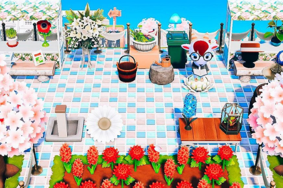 Animal Crossing - a goat villager sits in the middle of an impeccable decorated patio in the sunlight.