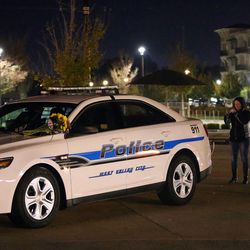 The parents of West Valley police officer Cody Brotherson, who died in the line of duty, visit his patrol car with other family and friends outside the police station in West Valley City on Monday, Nov. 7, 2016.
