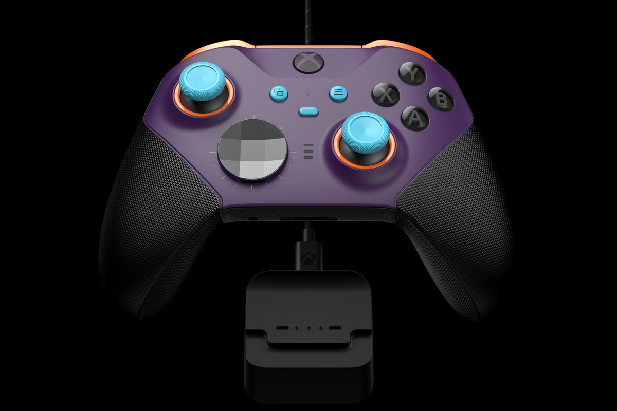 A mostly purple Xbox Elite controller with hints of orange and sky blue. The controller is very lightly illuminated, on a stand, in front of a black background.