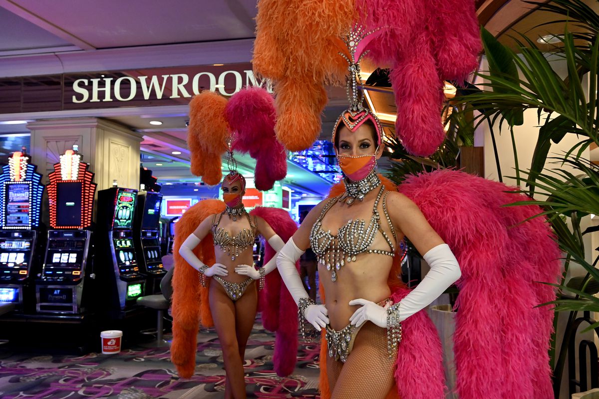 Two showgirls at the Flamingo Las Vegas wear masks, which become mandatory ...