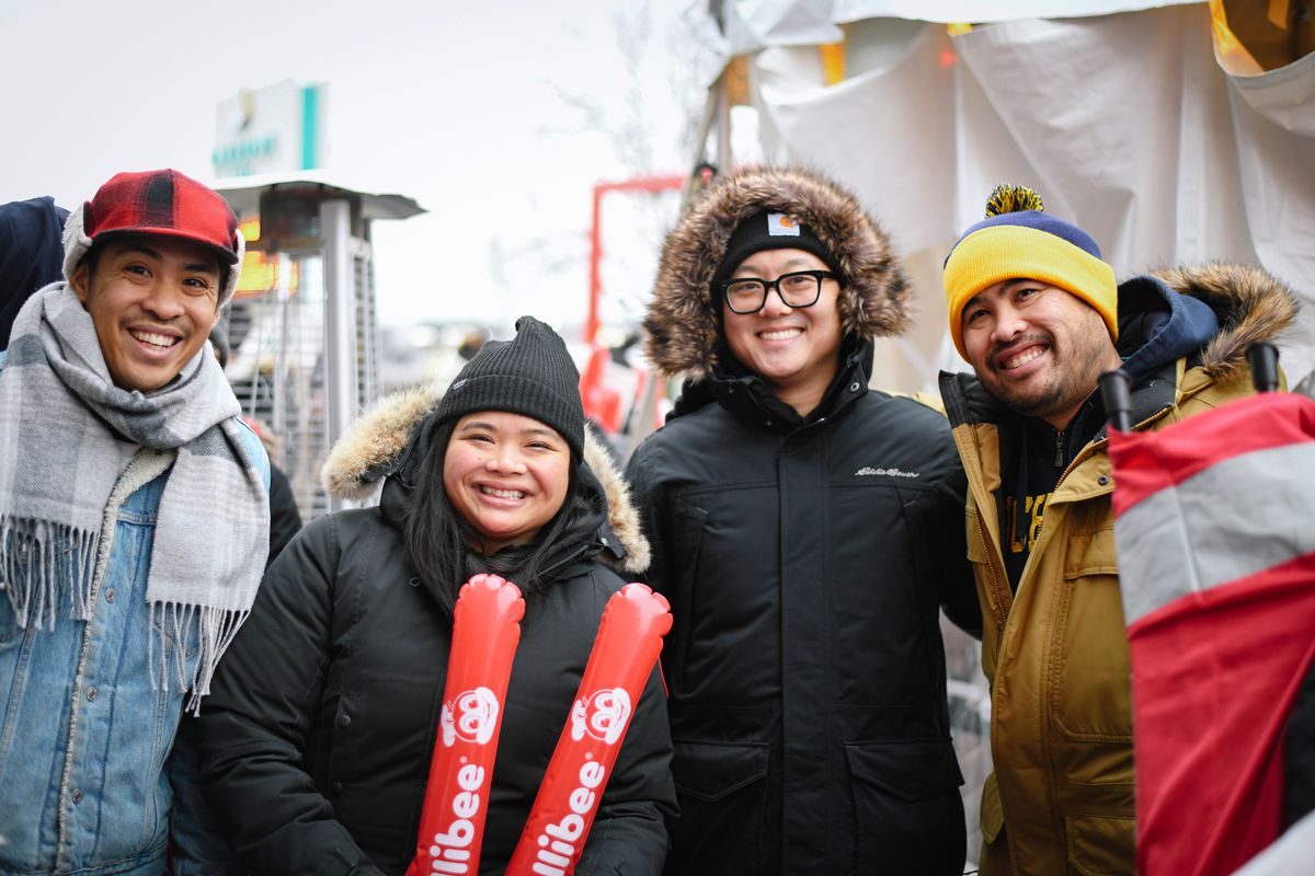 A crowd of people wearing winter gear outside of Jollibee in Sterling Heights, Michigan.
