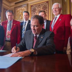 Utah Gov. Gary Herbert signs HB127, which adds the "In God We Trust" license plate to the standard options available, at the Capitol in Salt Lake City on Monday, March 21, 2016.
