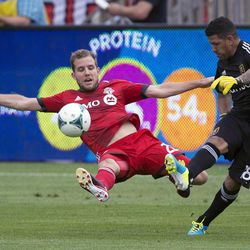 Toronto FC forward Jeremy Brockie, left, dives in with a sliding challenge as Real Salt Lake goalkeeper Eduardo Fernandez clears ball during the first half of an MLS soccer game in Toronto on Saturday June 29, 2013. (AP Photo/The Canadian Press, Frank Gunn)