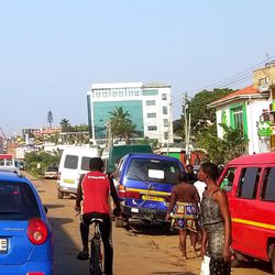 A scene in the sandy streets of Greater Accra Region that flow with traffic and people and where merchants line the sides of the busy throughfare.