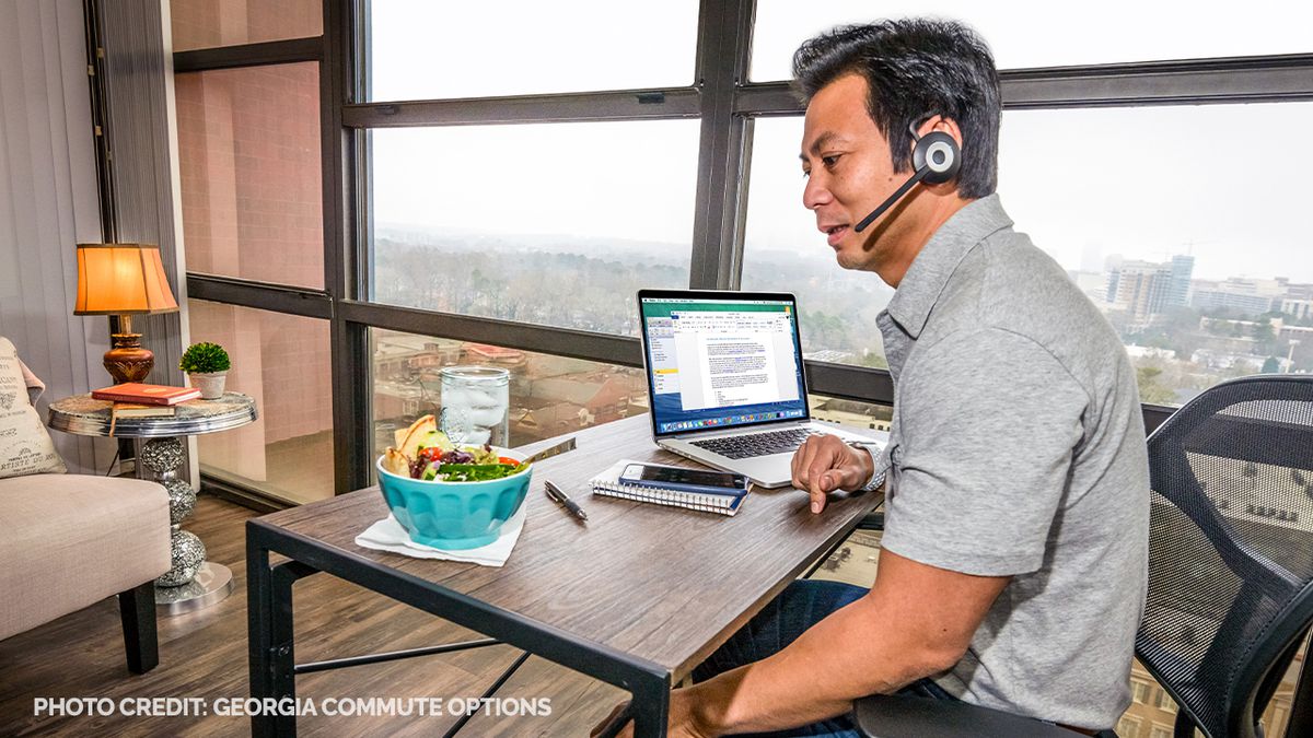 A man talks on his headset while working from home. 