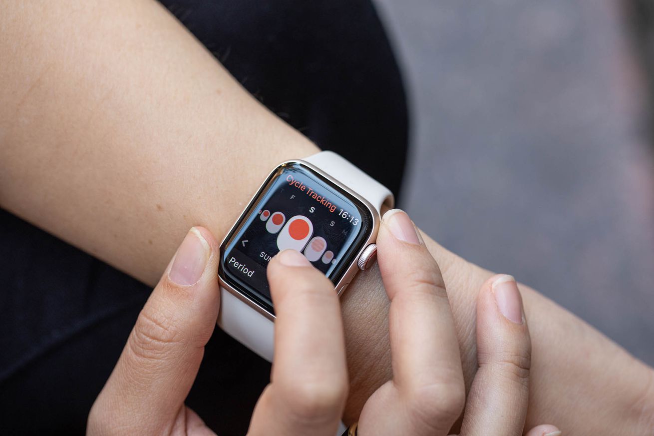 Apple Watch on a wrist showing a screen that lets a user log a period
