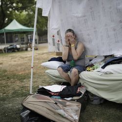 Starla Davis cries as she packs a suitcase in her makeshift tent at an evacuation center Thursday, Aug. 9, 2018, in Redding, Calif. Davis was living with a friend near Whiskytown and had to evacuate because of the Carr Fire. The evacuation center closes on Aug. 10. (AP Photo/John Locher)