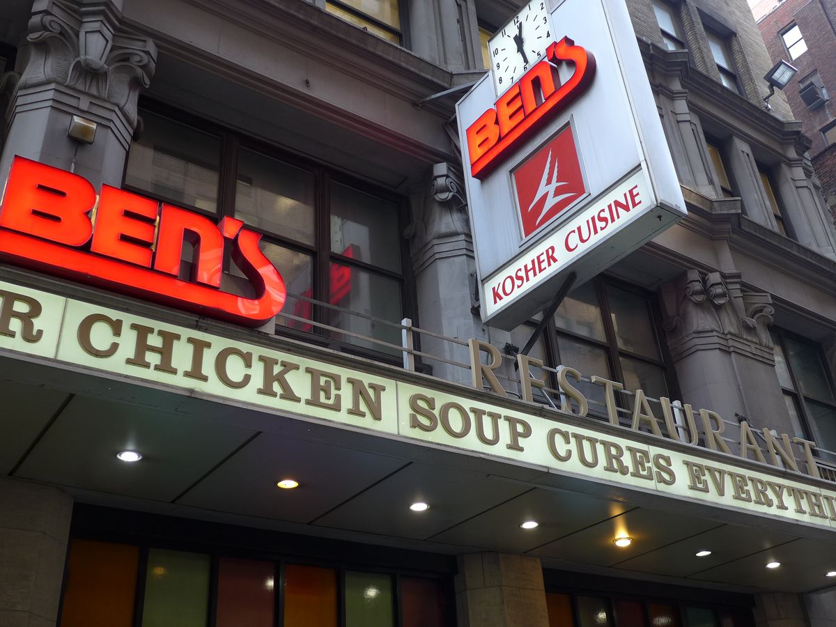 A large neon sign in red lettering sits on the side of the building and reads: “Ben’s Restaurant: Chicken Soup Cures Everything”