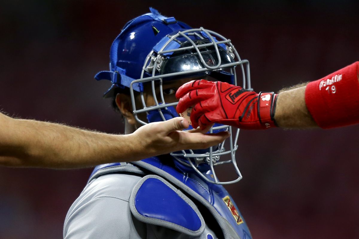Umpire Jeff Kellogg (8) takes the ball from Cincinnati Reds second baseman Jose Peraza (9) as Kansas City Royals catcher Salvador Perez (13) watches in the fourth inning at Great American Ball Park. 