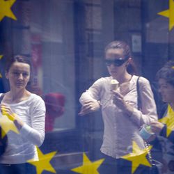 A street scene is reflected in the window of a library with an EU flag on display  in downtown  Zagreb, Croatia, Sunday, June 30, 2013. Croatia is to join the European Union on July 1, 2013. 