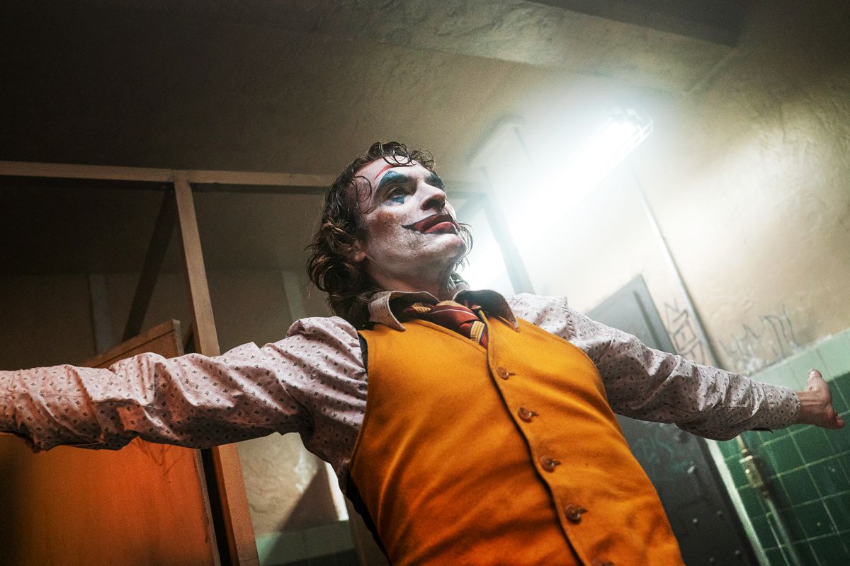 Joaquin Phoenix as the Joker spreads his arms wide.