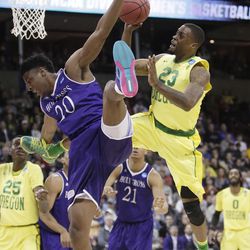 Oregon forward Elgin Cook (23) is fouled by Holy Cross forward Jehyve Floyd (20) as he shoots during the second half of a first-round men's college basketball game in the NCAA Tournament in Spokane, Wash., Friday, March 18, 2016. (AP Photo/Young Kwak)