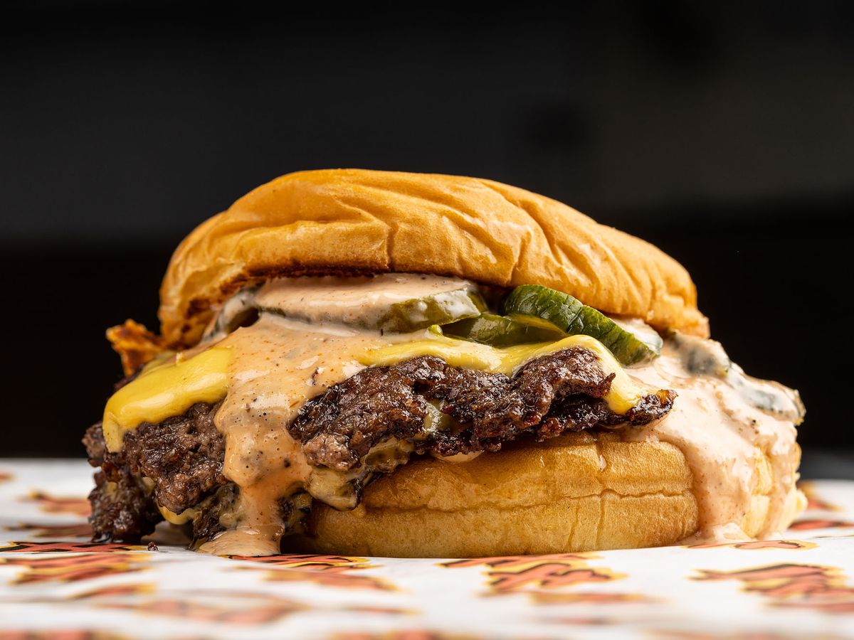 A cheeseburger topped with pickles, sauce, and caramelized onions from Heavy Handed.