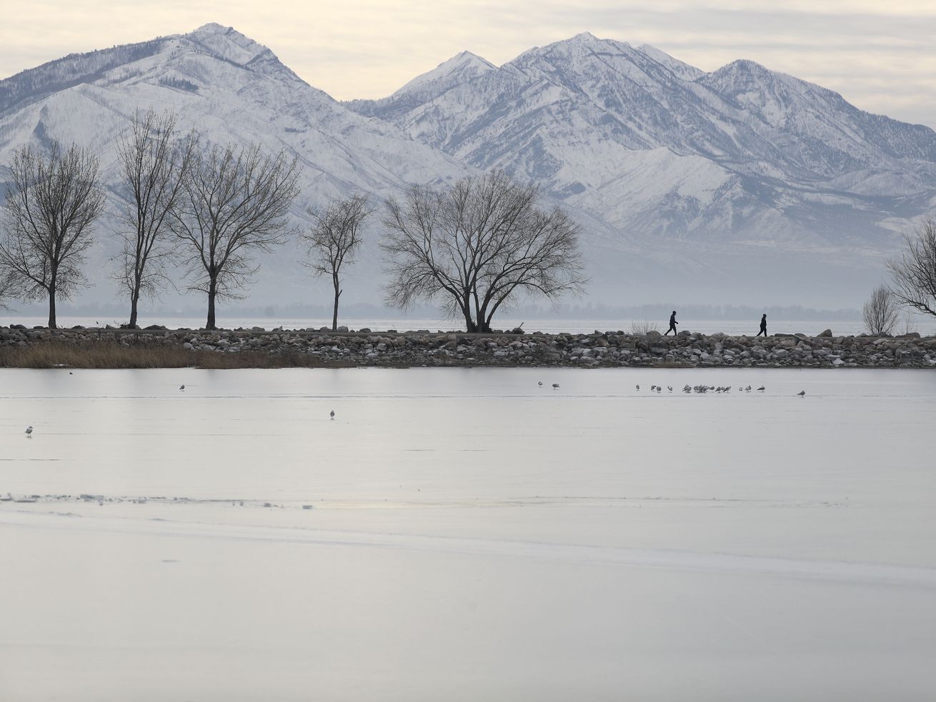 People walk on a jetty in Utah Lake State Park in Provo on Thursday, Jan. 13, 2022. Stakeholders gathered at Utah Valley University this week to discuss the future of the lake, including scientists, lawmakers, government officials and the public.