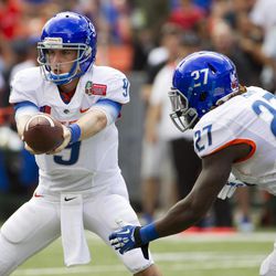 Boise State quarterback Grant Hedrick (9) hands off the football to his teammate running back Jay Ajayi (27) in the second quarter of the Hawaii Bowl NCAA college football game against Oregon State, in Honolulu, Tuesday, Dec. 24, 2013. 