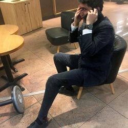 In this photo provided by Georgian Public Broadcaster and photographed by Ketevan Kardava a man speaks on a mobile phone in Brussels Airport in Brussels, Belgium, after explosions were heard Tuesday, March 22, 2016. A developing situation left a number dead in explosions that ripped through the departure hall at Brussels airport Tuesday, police said. All flights were canceled, arriving planes were being diverted and Belgium's terror alert level was raised to maximum, officials said. 
