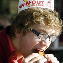 Mountain View High student David Eldridge is one of the first to enjoy an IN-N-OUT burger at the new Orem restaurant, which opened at 9 a.m. Thursday to many happy customers. 