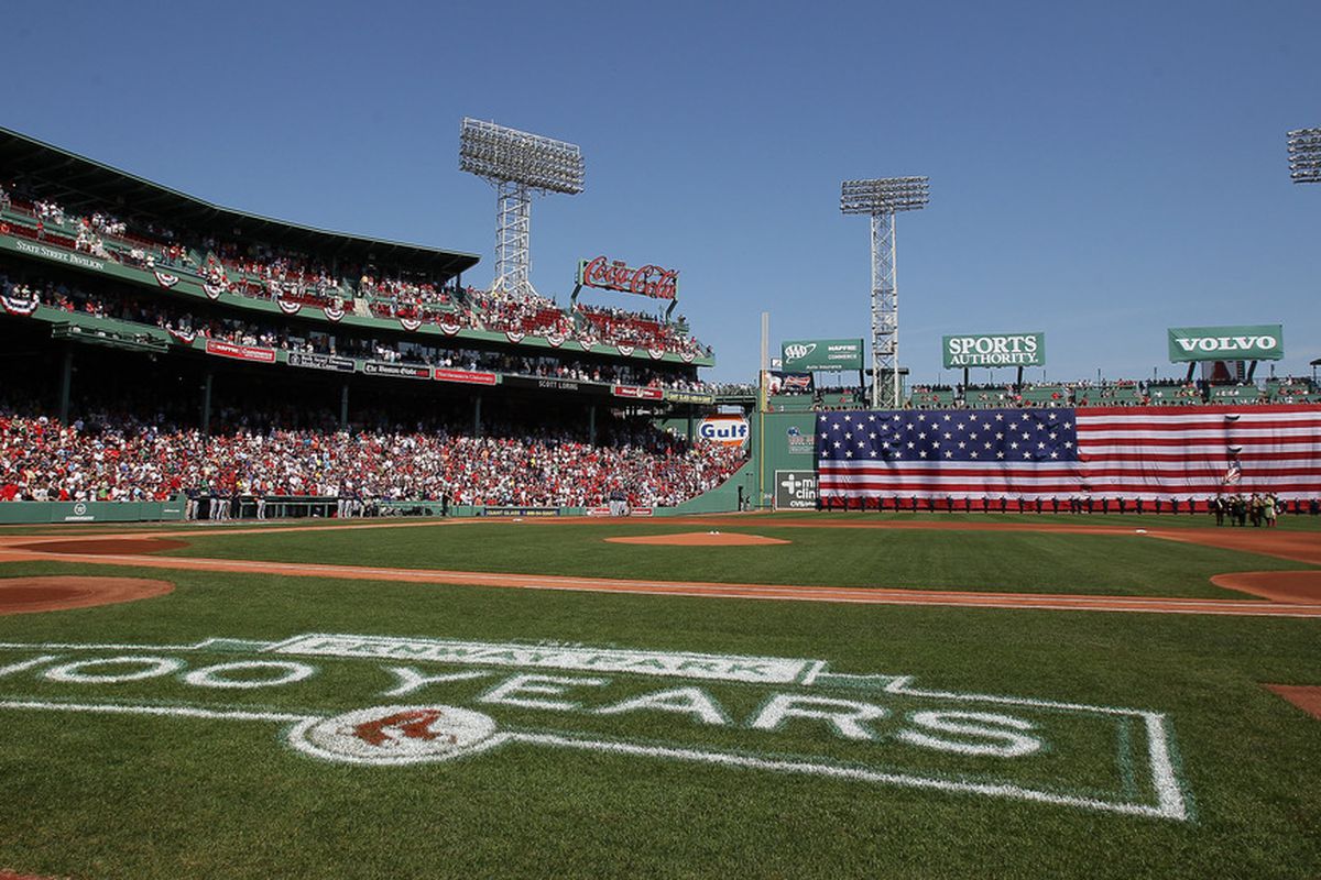 BOSTON, MA - APRIL 16:  The flag covers the Green Monster as the national anthem is played before the game between the Boston Red Sox and the Tampa Bay Rays on April 16, 2012 at Fenway Park in Boston, Massachusetts.  (Photo by Elsa/Getty Images)
