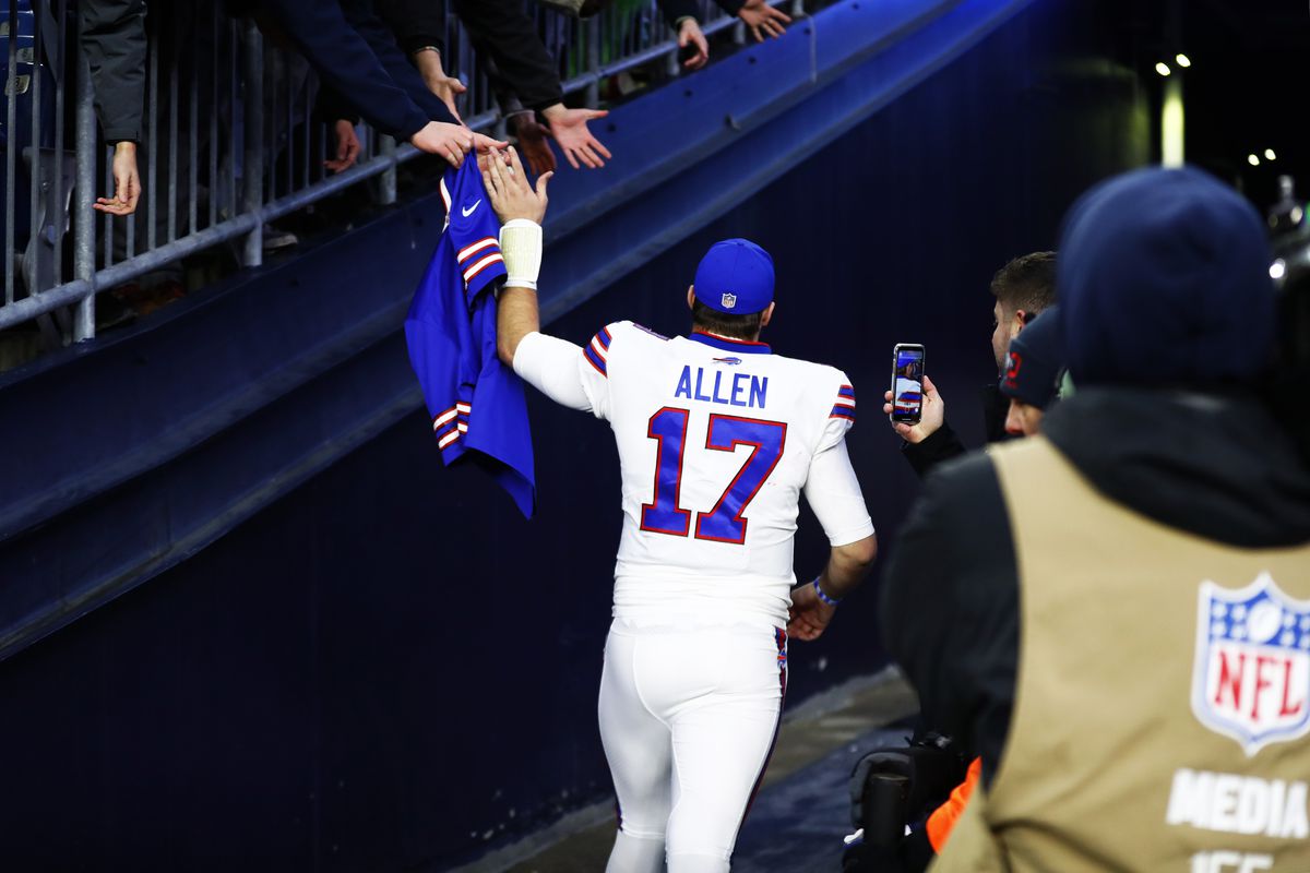 Quarterback Josh Allen #17 of the Buffalo Bills high-fives a fan as he heads down the tunnel after the victory against the New England Patriots at Gillette Stadium on December 26, 2021 in Foxborough, Massachusetts.