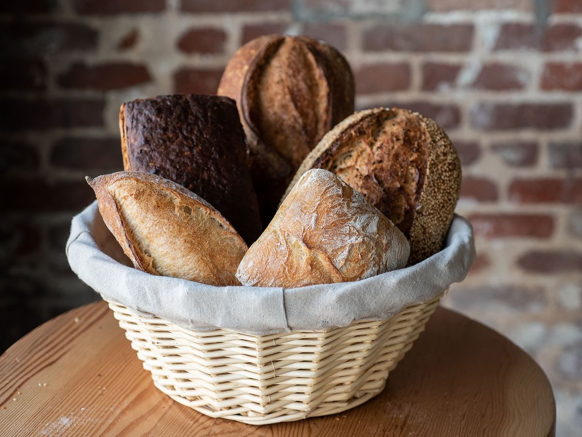 A basket of freshly baked breads on varying sizes.