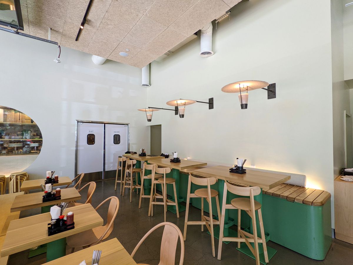 Wooden seats and light green touches at a new restaurant at daytime.