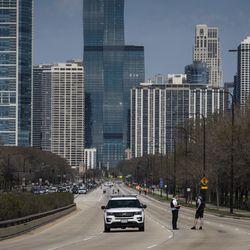 Chicago police investigate in the northbound lanes of Lake Shore Drive at East Monroe Street, where a 2-year-old boy was shot in the head while he was traveling inside a car near Grant Park, Tuesday, April 6, 2021.
