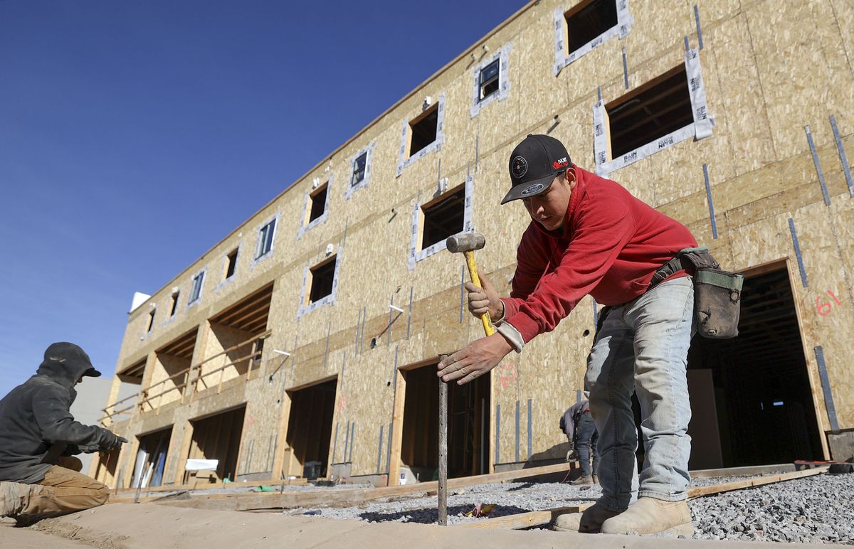 Omar Miranda, leader concrete carpenter, helps form driveways for concrete for new town houses under construction at Park Lofts at City Center, by Brighton Homes, in North Salt Lake on Friday, Feb. 18, 2022.