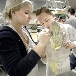 Jordan High students Sarah Brazell and Kameron Hadlock work together to fill a pastry bag. The culinary arts program may be axed.