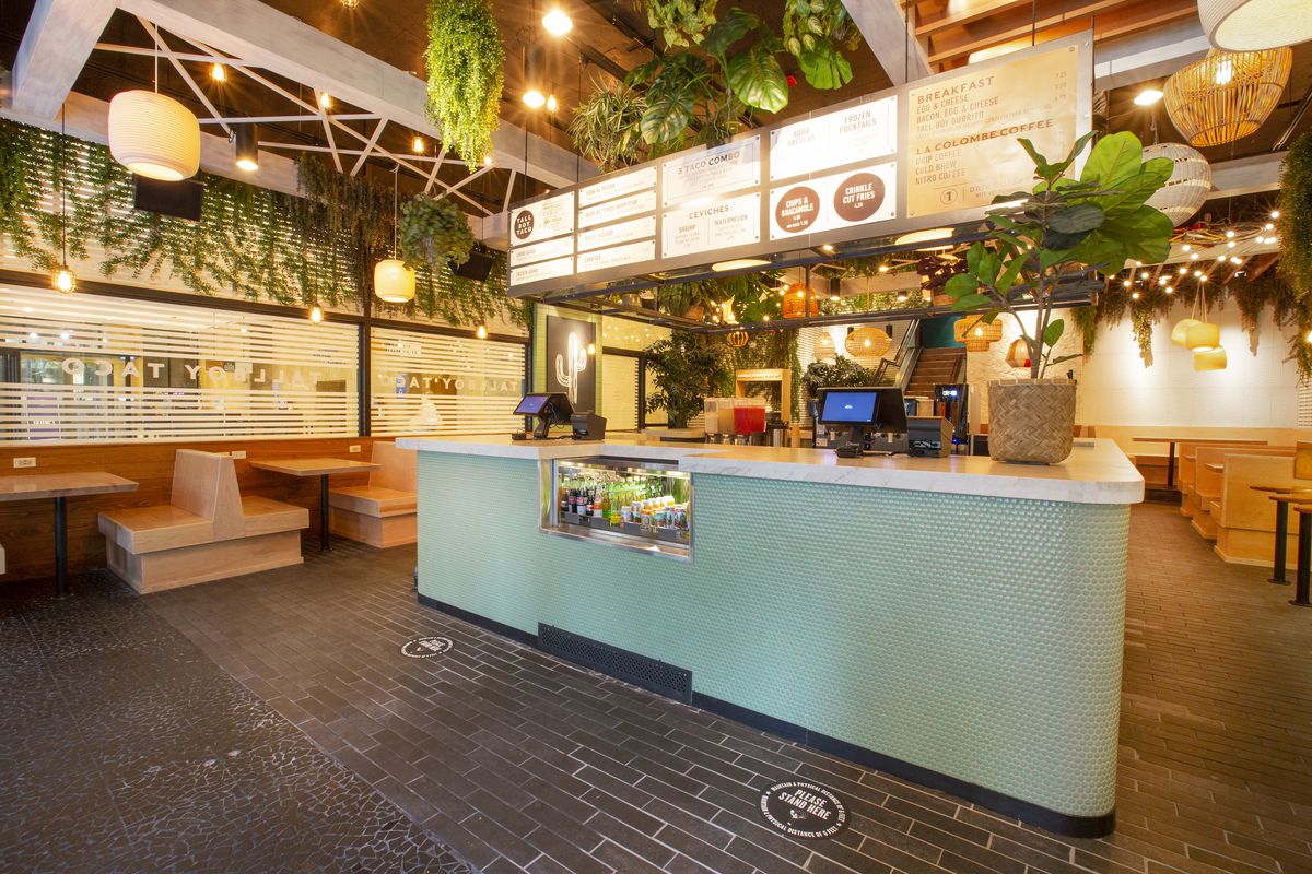 A green tiled island counter in the middle of a restaurant space.