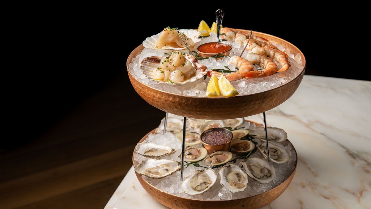 A two-tier system of trays at a seafood restaurant on a marble table.