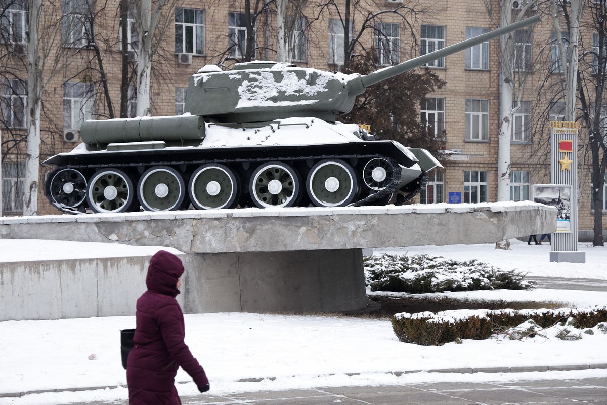 A woman walks past a tank in Kyiv, Ukraine.