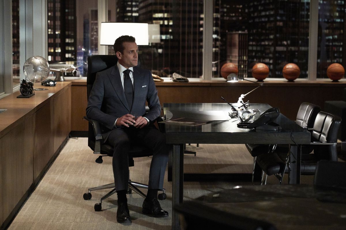 Still photo from Suits showing Gabriel Macht as Harvey Specter sitting alone in his office.