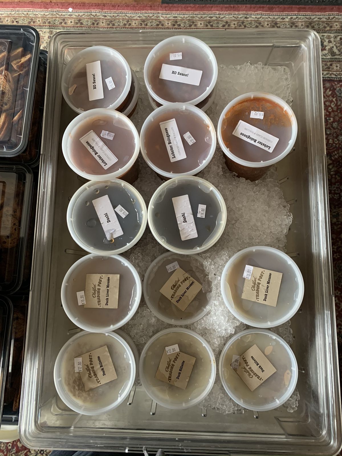 A tray filled with ice containing boxes of condiments in plastic containers