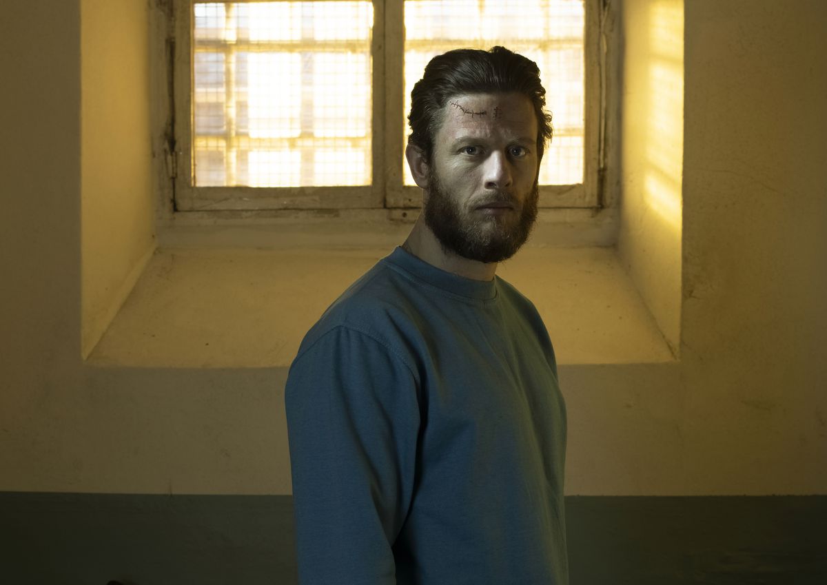 James Norton as Tommy Lee Royce in Happy Valley: a mean looking bearded man with stitches in his forehead in a prison cell