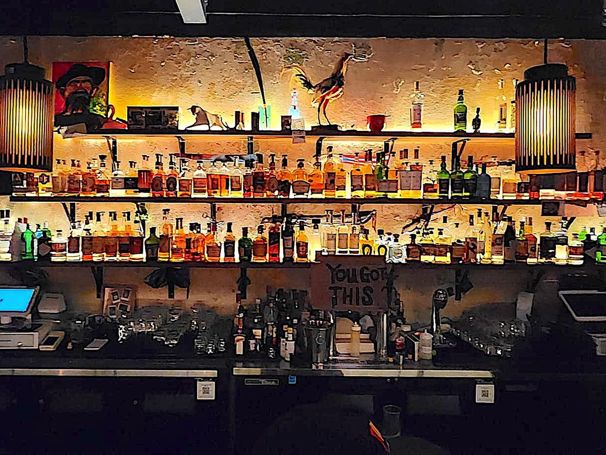 Rows of bottles on a backlit bar.