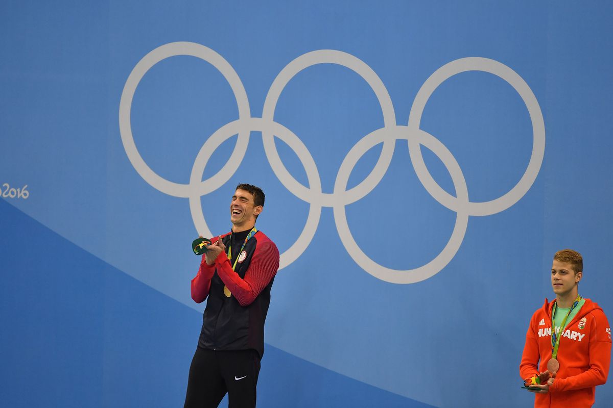 Michael Phelps laughs during a medal ceremony because his “boys from Baltimore” did the “O!” during the anthem.