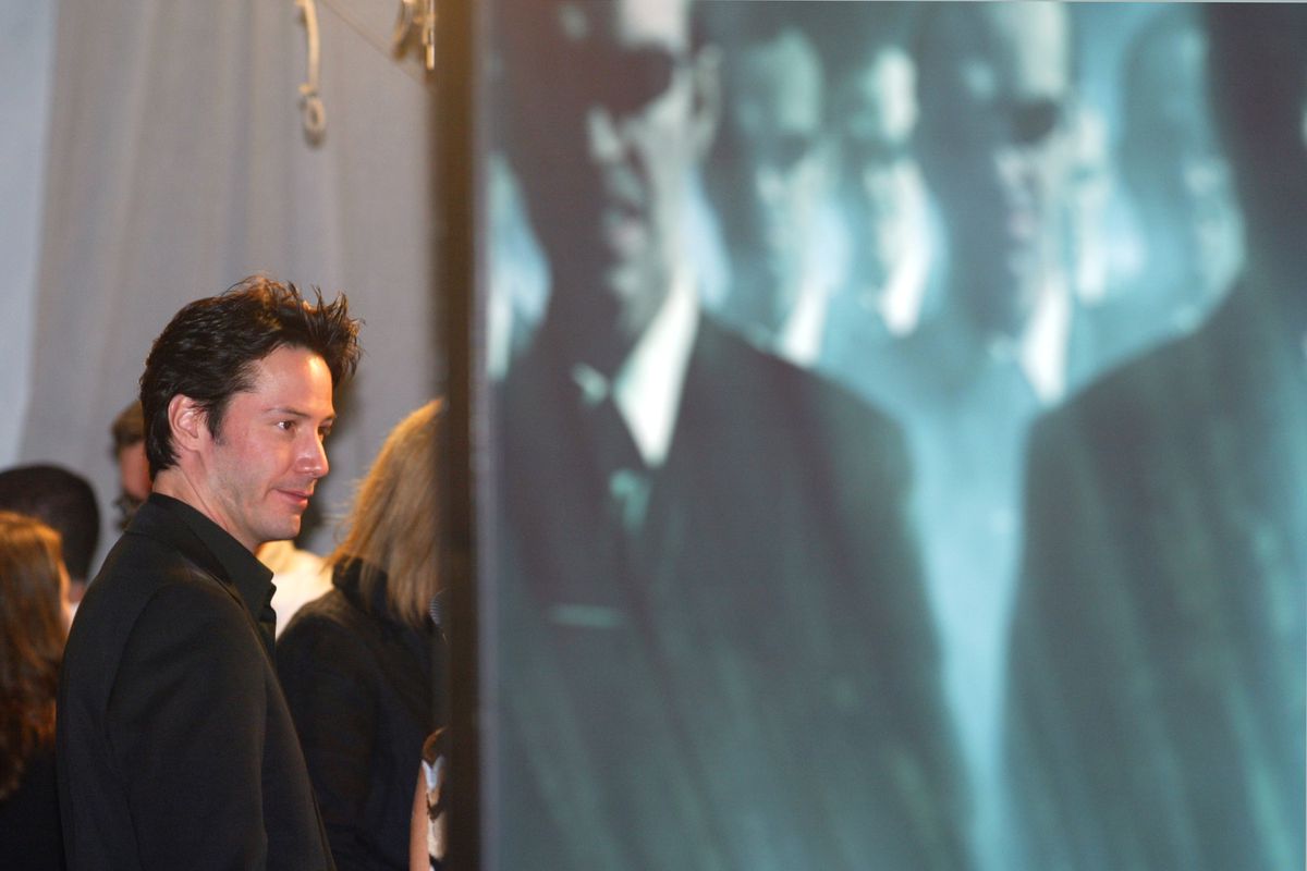 Actor Keanu Reeves comes face to face with a movie poster sporting the image of Hugo Weaving as Smit