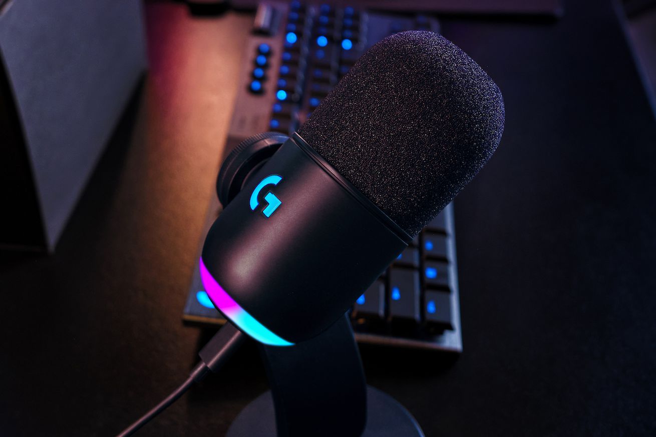 A picture of the Yeti GX microphone sitting on a desk with pink and blue RGB lighting on the bottom.