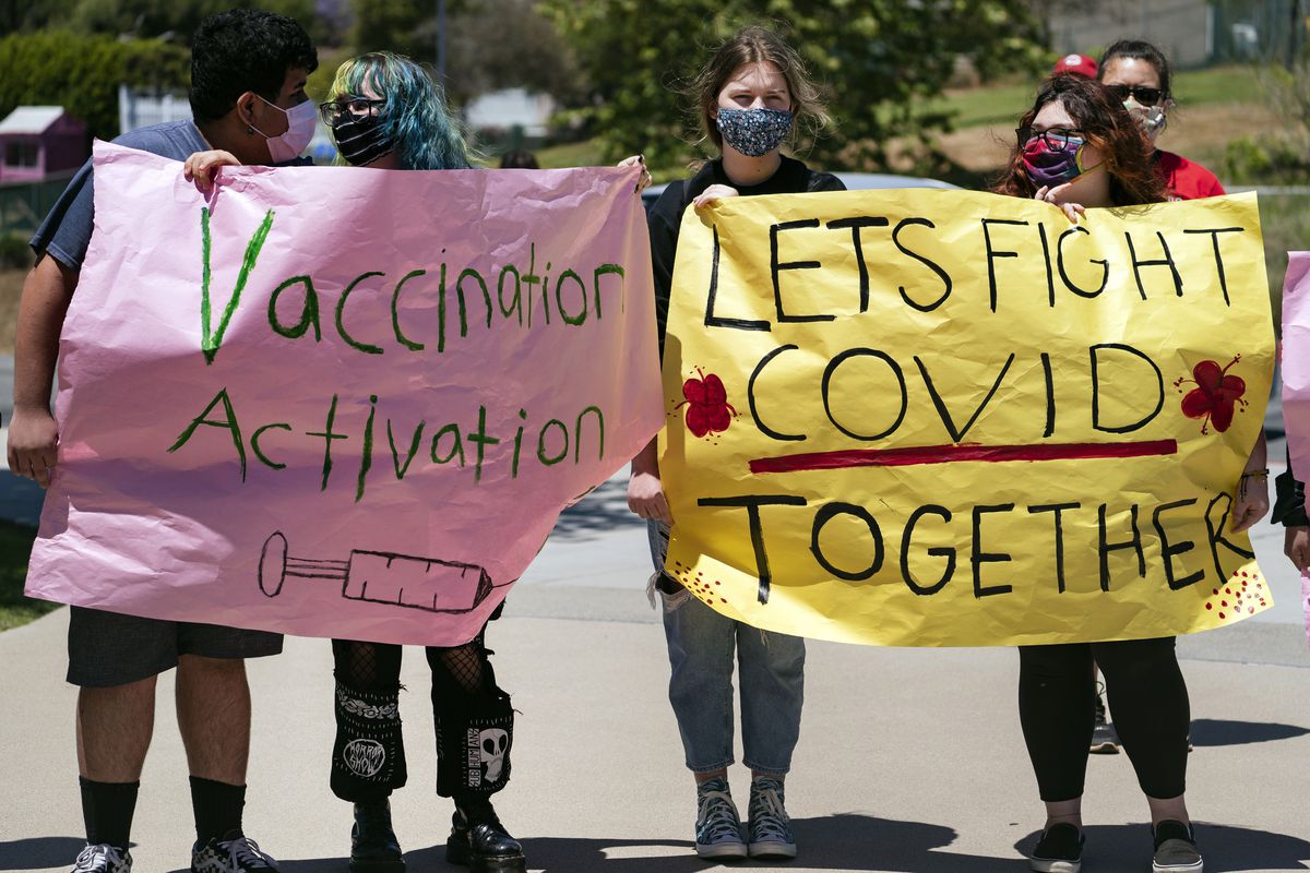 San Pedro High School students hold vaccination signs at a school-based COVID-19 vaccination event for students 12 and older in San Pedro, Calif., Monday, May 24, 2021. Schools are turning to mascots, prizes and contests to entice youth ages 12 and up to get vaccinated against the coronavirus before summer break. 